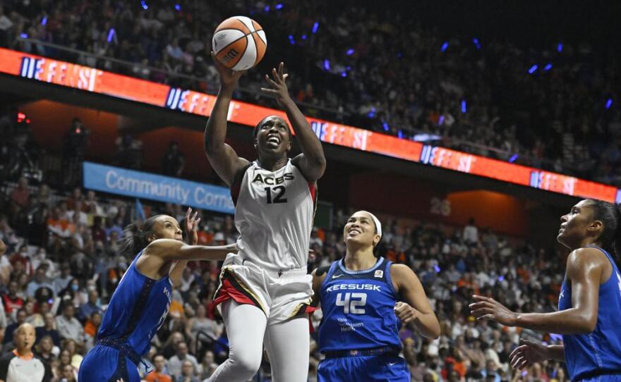 The Las Vegas Aces' Chelsea Gray (12) goes up for a basket as the Connecticut Sun's DeWanna Bonner (left) and Brionna Jones (42) defend during the second half in Game 4 of the WNBA basketball Finals, Sunday, Sept. 18, 2022, in Uncasville, Conn.