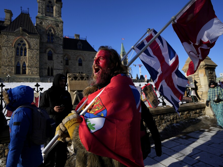 A protester yells "freedom" towards a person who attempted to stick a paper sign on a truck criticizing the Freedom Convoy protest against COVID-19 measures on Monday.