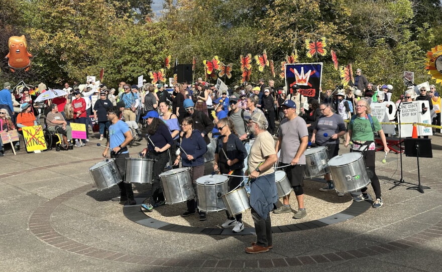 People playing drums before a crowd. 