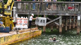 Clark and Clay Lancaster lower the artificial reef into the waters of Lake Norman State Park. 