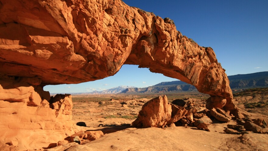 Sunset Arch rises from a sagebrush and slickrock flat in the Grand Staircase-Escalante National Monument in Utah.