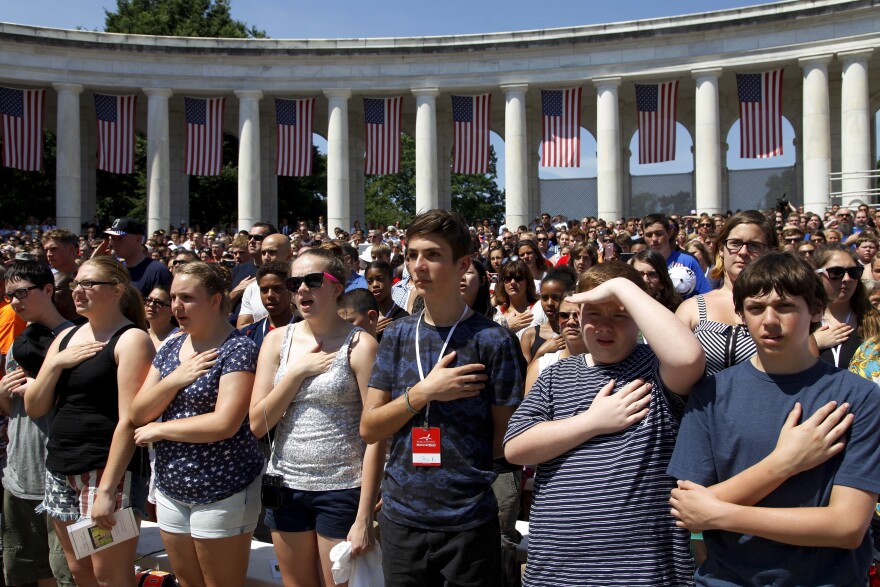 Crowds stand for the national anthem during the Memorial Day observance at Arlington National Cemetery.