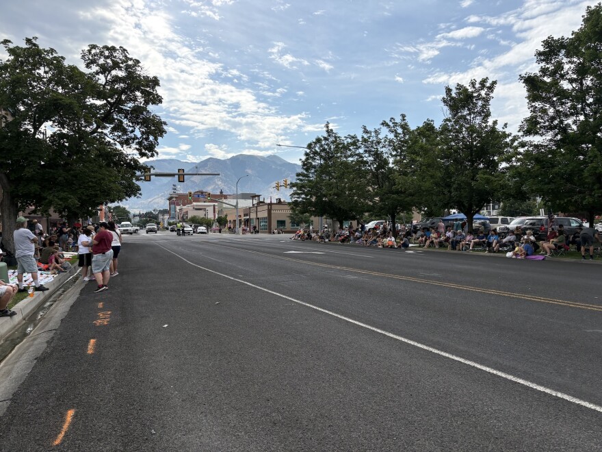 Road with people lined up on the side for parade.
