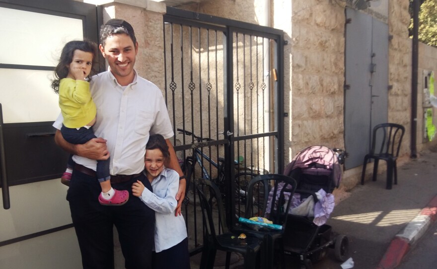 Yosef Eharman, 33, with his children, stands in front of their home in an ultra-Orthodox enclave of Jerusalem. Eharman recently left the Jewish seminary, or yeshiva, where he had studied since childhood, to train as an electrical engineer. He is now working in a solar energy company.