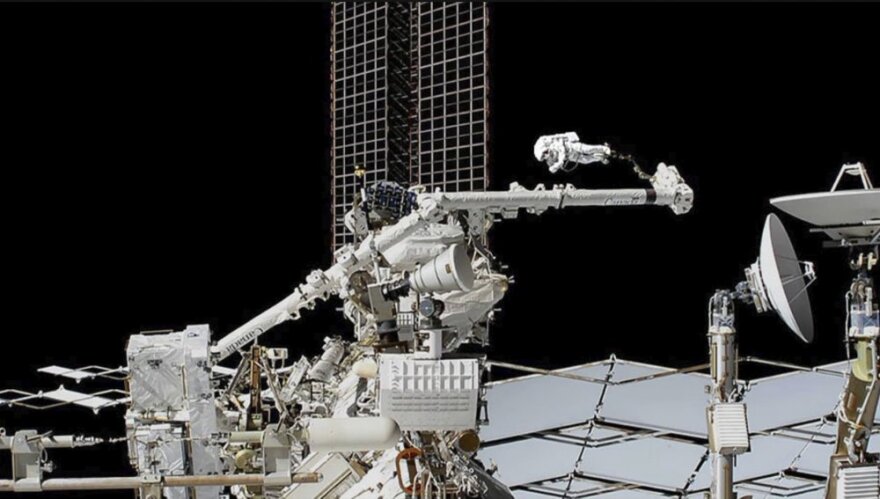 Astronauts work on cosmic ray detector