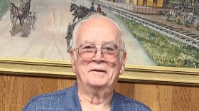 A photo of a man with grey hair and glasses.