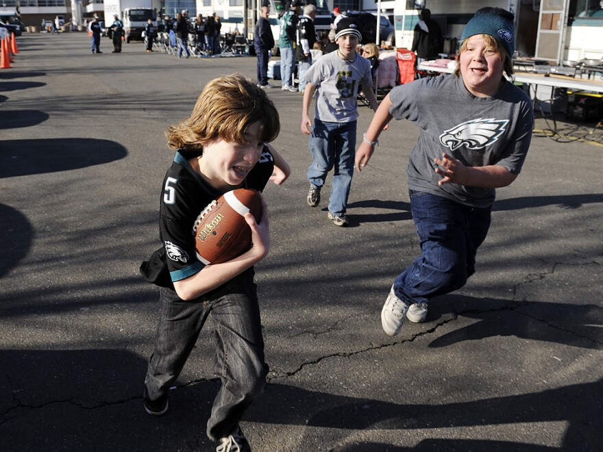Kids playing a game of touch football in the parking lot of Lincoln Financial Field before the start of an NFL football game between the Philadelphia Eagles and the Denver Broncos Sunday, Dec. 27, 2009, in Philadelphia.