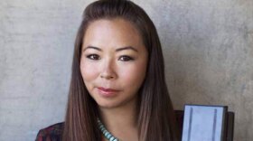 A headshot of Matika Wilbur holding a camera.