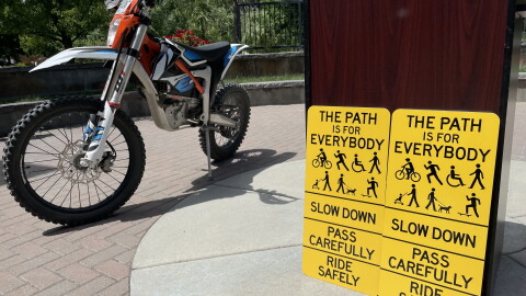 New signs on the Greenbelt will remind users to slow down and share the pathway. Some e-bikes, like the off-roading dirt bike pictured above, require permits and are not allowed on the Greenbelt.