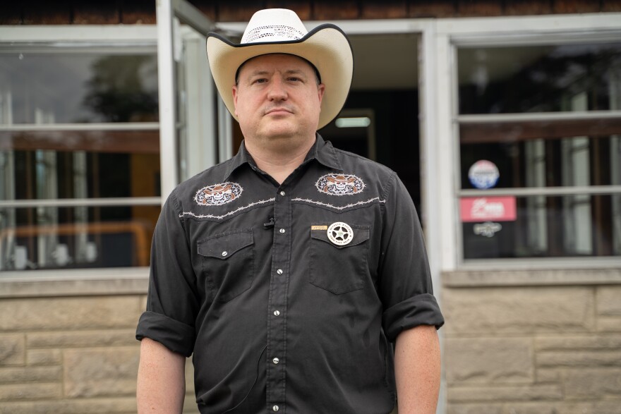 Man in black shirt and white cowboy hat.