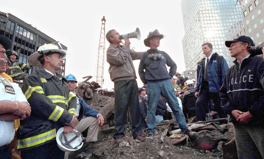 President George W. Bush speaks to rescue workers from the rubble of Ground Zero on Sept. 14, 2001 in New York City. Bush's moves for tougher immigration measures won widespread support then, compared to the resistance President Trump is facing today.