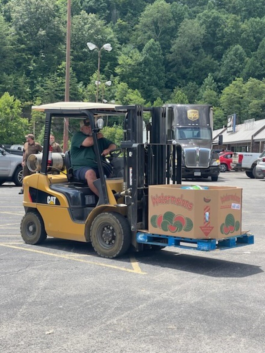 Workers move a crate of watermelons for distribution to flood victims in Eastern Kentucky