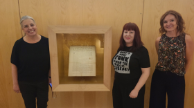 From left, Melissa Dease, Misty Maberry and Kristen Calvert pose with the original copy of the Declaration of Independence housed in the Dallas Public Library on Oct. 16, 2025.