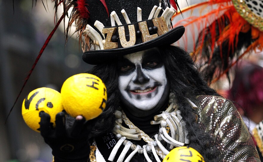 A member of the Krewe of Zulu parades down St. Charles Avenue on Mardi Gras Day in New Orleans.