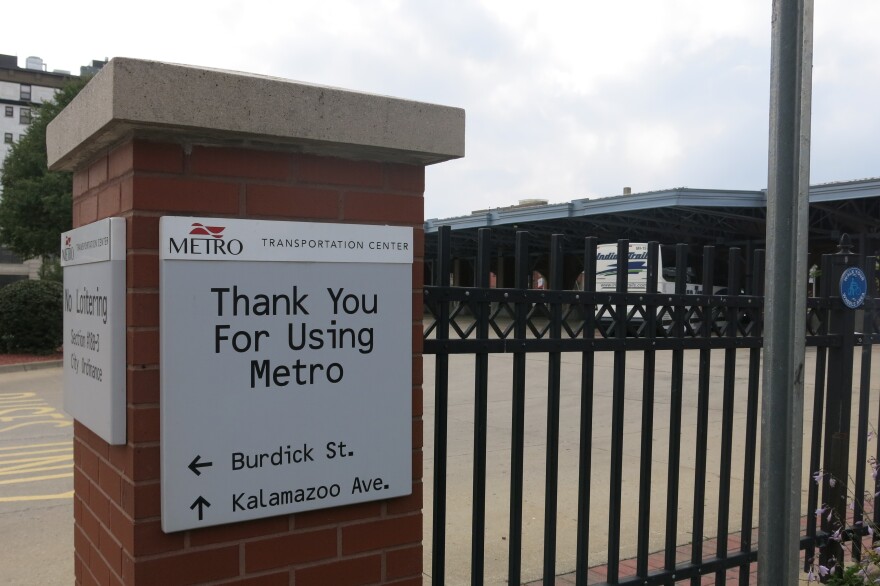 Photo of a grey-and-white sign on a square brick post that says "Thank you for using Metro"