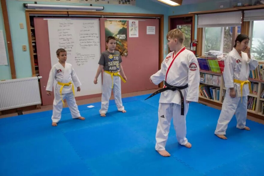 Jesse Dempsey helps instruct his peers during taekwondo class.
