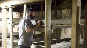 Tristan Mead inspects the mysterious bunk beds beneath the Veltus Building on Cooper Ave.