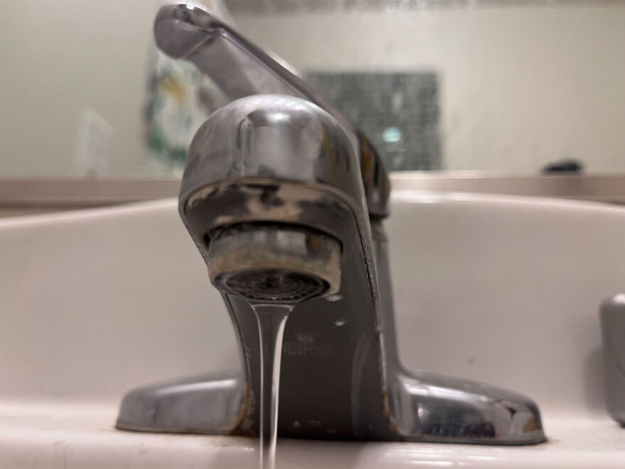 Water flows from a faucet.