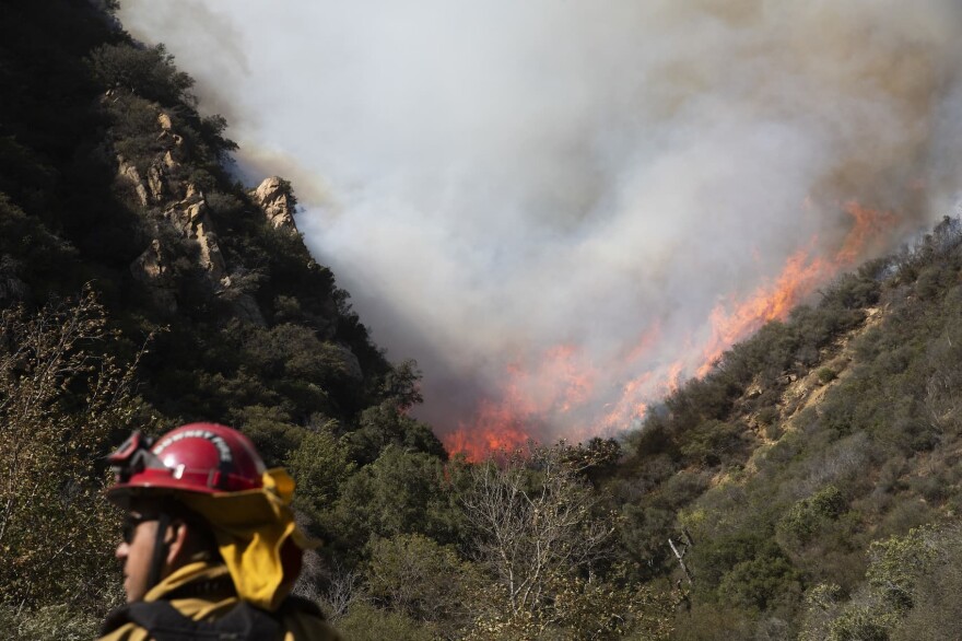 A firefighter monitors a wildfires burning along a hillside Sunday, Nov. 11, 2018, in Malibu, Calif. Fire officials say the lull allowed firefighters to gain 10 percent control of the so-called Woolsey fire, which has burned more than 130 square miles in western Los Angeles County and southeastern Ventura County since Thursday. (Jae C. Hong/AP)