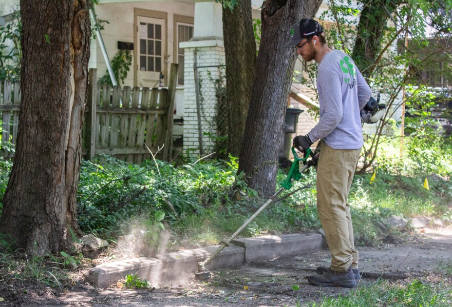 SB Mowing owner Spencer edges a sidewalk while working in a Wichita neighborhood on Friday afternoon.