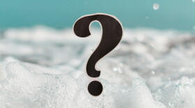 Close-up of bubbles in a bubble bath; a question mark in the foreground