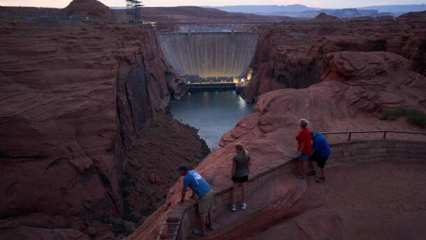 People view the Glen Canyon Dam from a viewpoint above the Colorado River, Tuesday, July 14, 2026, in Page, Ariz. (AP Photo/John Locher)