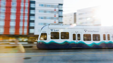 A train passes in front of apartment buildings. 