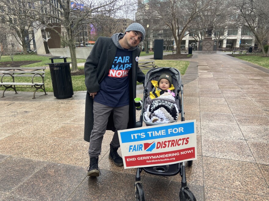 A father and child attend a protest over redistricting at the Ohio Statehouse on March 25, 2022