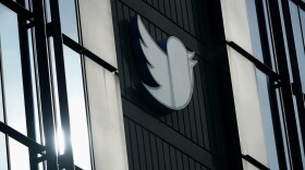 A Twitter logo hangs outside the company's offices in San Francisco, on Dec. 19, 2022. 