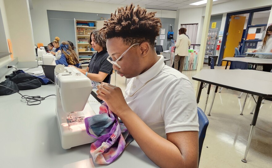 Freshman Jabari Oyugi sews a dress that will be sent to Africa.