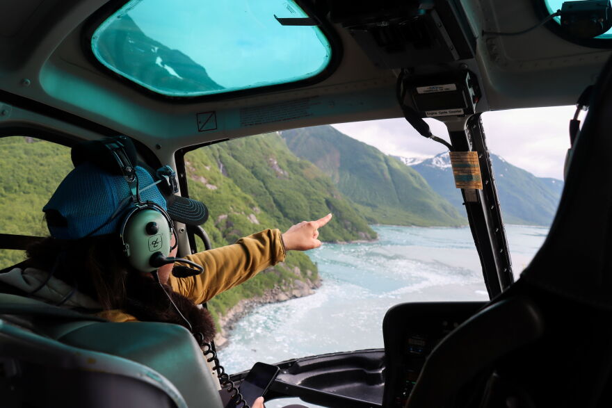 Melenda Lekanof points out landslide paths and signs of instability along the east side of Disenchantment Bay during a helicopter ride between the Valerie Glacier and Yakutat.
