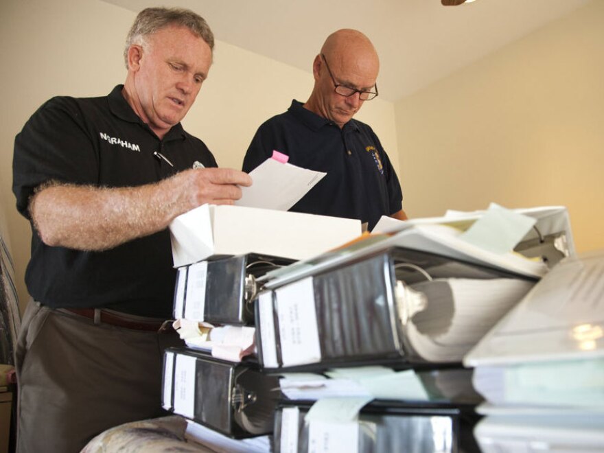 Larry Ingraham (left) and friend Donovan Jacobs review case files they have accumulated on Van Ingraham's death.
