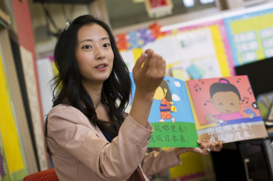 Teacher Tingting Mei reads a book in Mandarin to kindergarteners. Mei says repetition is how she helps her students master the language.