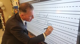 State Rep. Dane Watro signs his name on the board in Diane Mussoline’s classroom at Valley Elementary/Middle School.