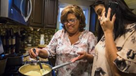 Irma Flores stirs milk while her daughter Gabriela Portillo-Perez speaks with her grandmother Isabel in El Salvador. The Trump administration announced Monday it would be ending temporary protected status for refugees from El Salvador.