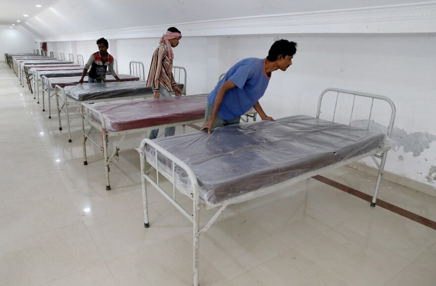 Workers prepare beds at a quarantine facility in Howrah on the outskirts of Kolkata, India.