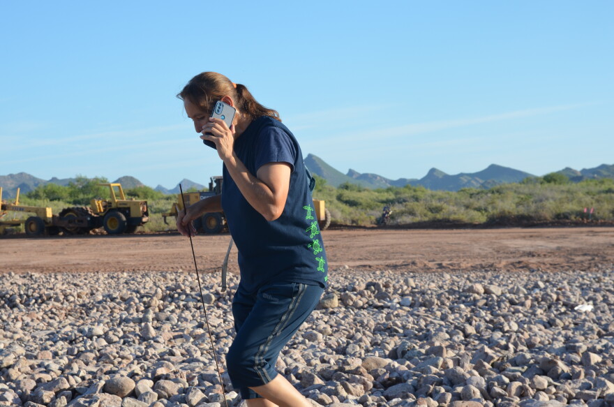Coria takes a phone call in what she says will become a 300-car parking lot just past the dunes at Playa San Francisco.