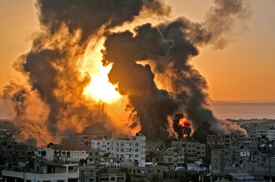 A fire rages at sunrise in the city of Khan Yunis following an Israeli airstrike in the southern Gaza Strip early on May 12.