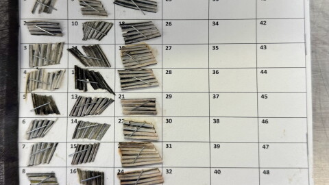 small fin clippings are stapled to a white car with 48 squares