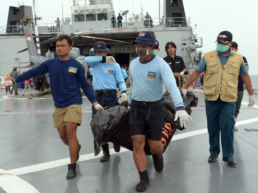 Indonesian Navy personnel carry a body bag from AirAsia Flight 8501, which crashed off the coast of Indonesian Borneo a week ago.
