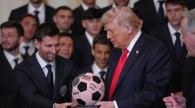 President Donald Trump receives a soccer ball trophy from Lionel Messi 