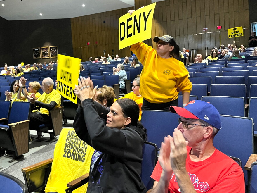 Local residents wave signs during closing arguments for the Wildcat Ridge Data Center campus' final zoning hearing.
