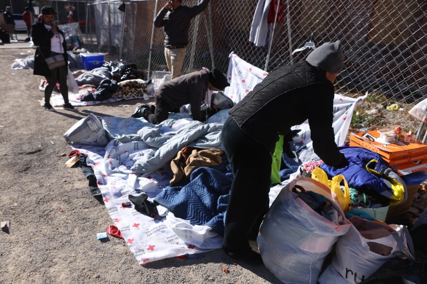 An asylum-seeking migrant from Valenzuela sorts through her belongings of hers, her husband's and four sons while they are living unsheltered after crossing the Rio Grande River into the United States in El Paso, Texas, U.S., December 22, 2022.