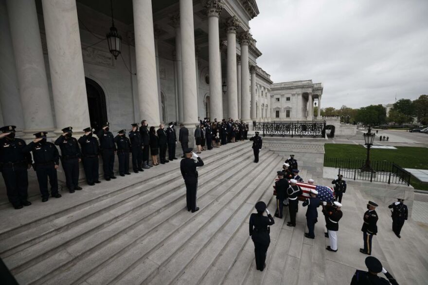 A casket containing the officer's remains is carried by a joint service honor guard into the Capitol on Tuesday.