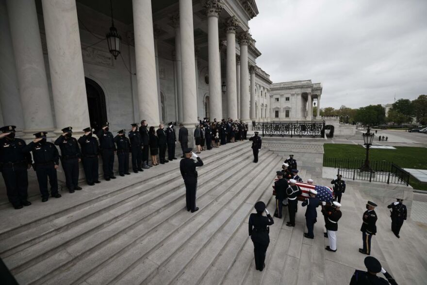 A casket containing the officer's remains is carried by a joint service honor guard into the  Capitol on Tuesday.