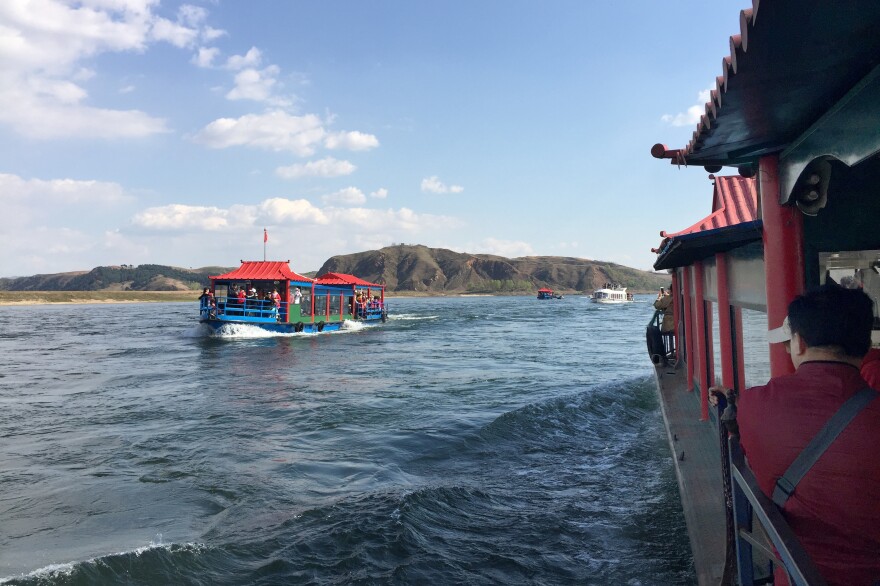 Chinese tourists ride ferryboats to the North Korean side of the Yalu River.