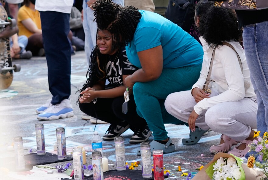 People mourn near a memorial at the site where a man was shot and killed on Wednesday by Madison police, Thursday, July 23, 2026, in Madison, Wisconsin.