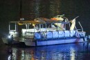 A ferry boat with the roof damaged in the water at night