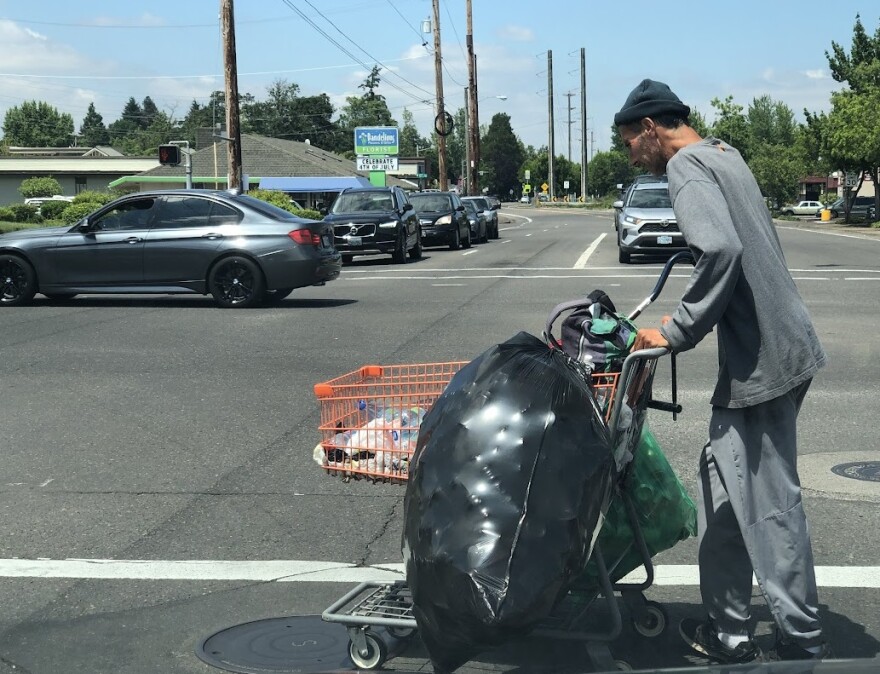 A homeless man crosses an intersection near West Eugene.