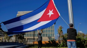 Workers fly the Cuban flag at half-mast at the Anti-Imperialist Tribune near the U.S. embassy in Havana, Cuba, Monday, Jan. 5, 2026, in memory of Cubans who died two days before in Caracas, Venezuela during the capture of Venezuelan President Nicolas Maduro by U.S. forces. (AP Photo/Ramon Espinosa)